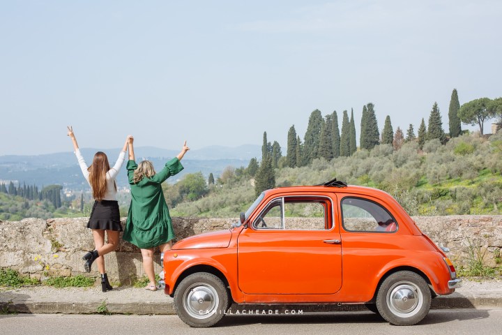 a group of people standing in front of a car