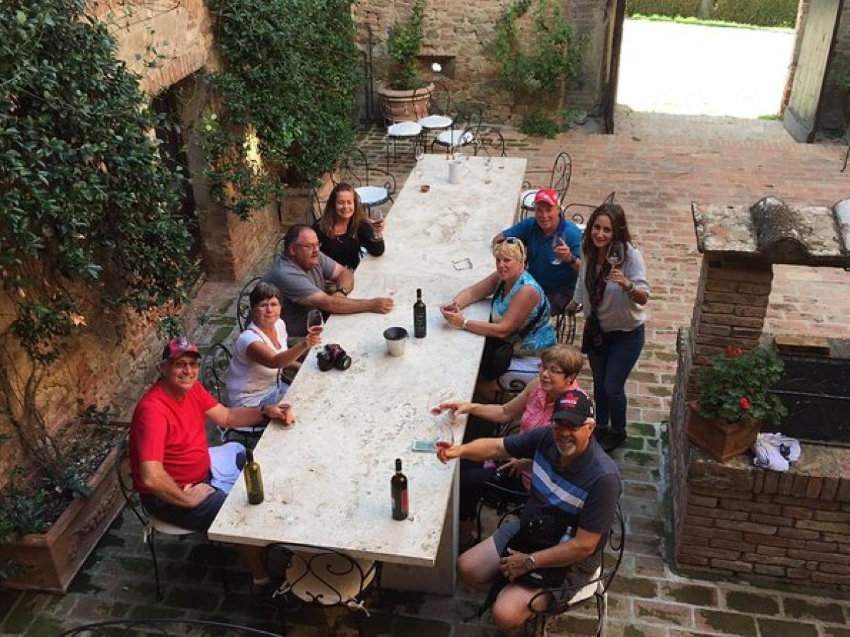 a group of people sitting on a bench in front of a brick building