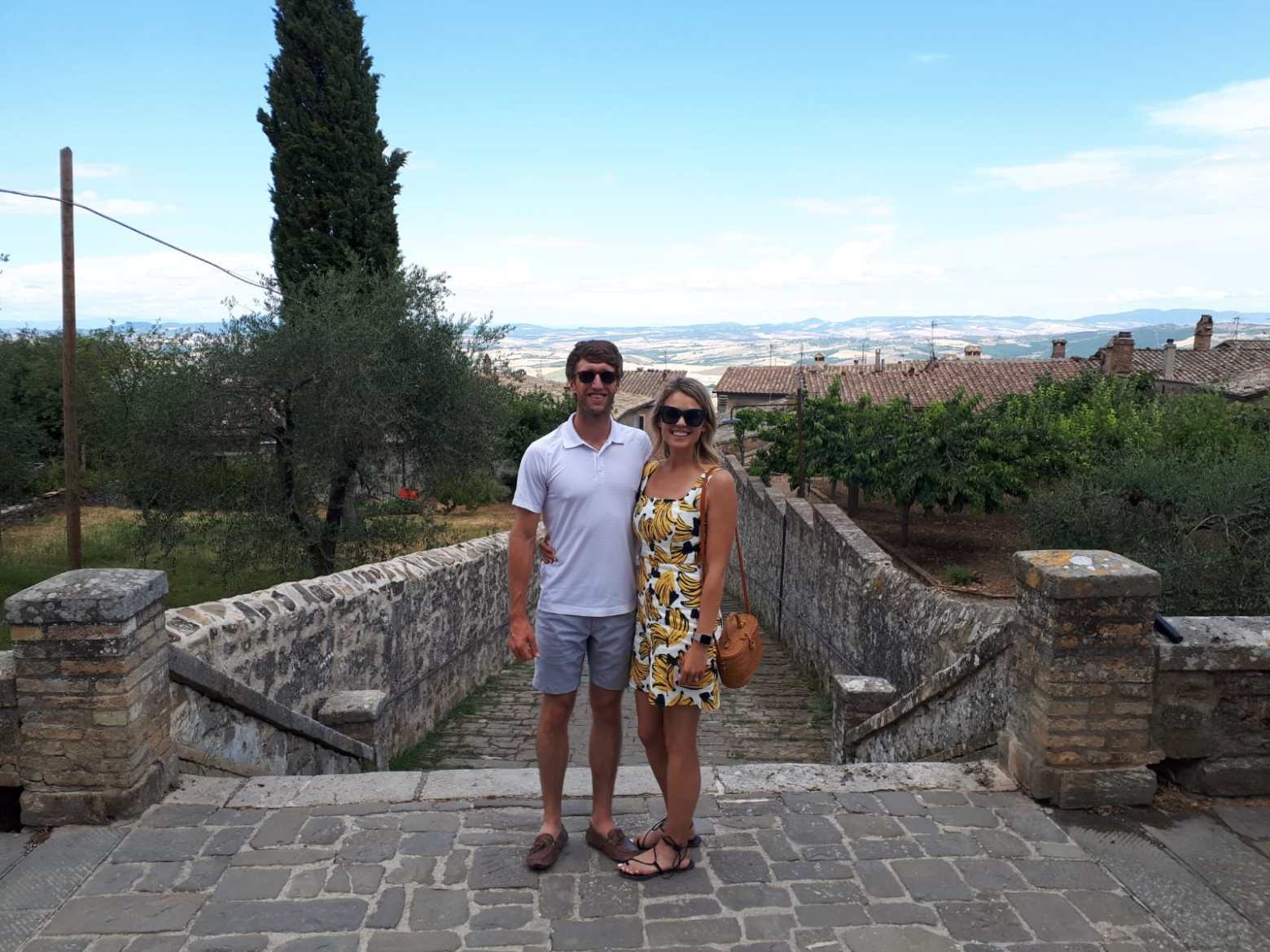 a man standing next to a stone wall