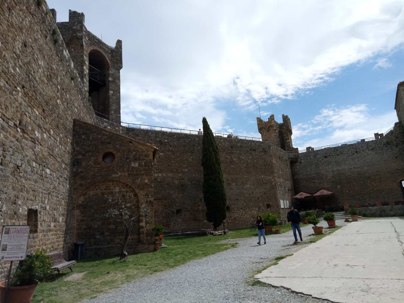 a stone castle next to a brick building with Ludlow Castle in the background