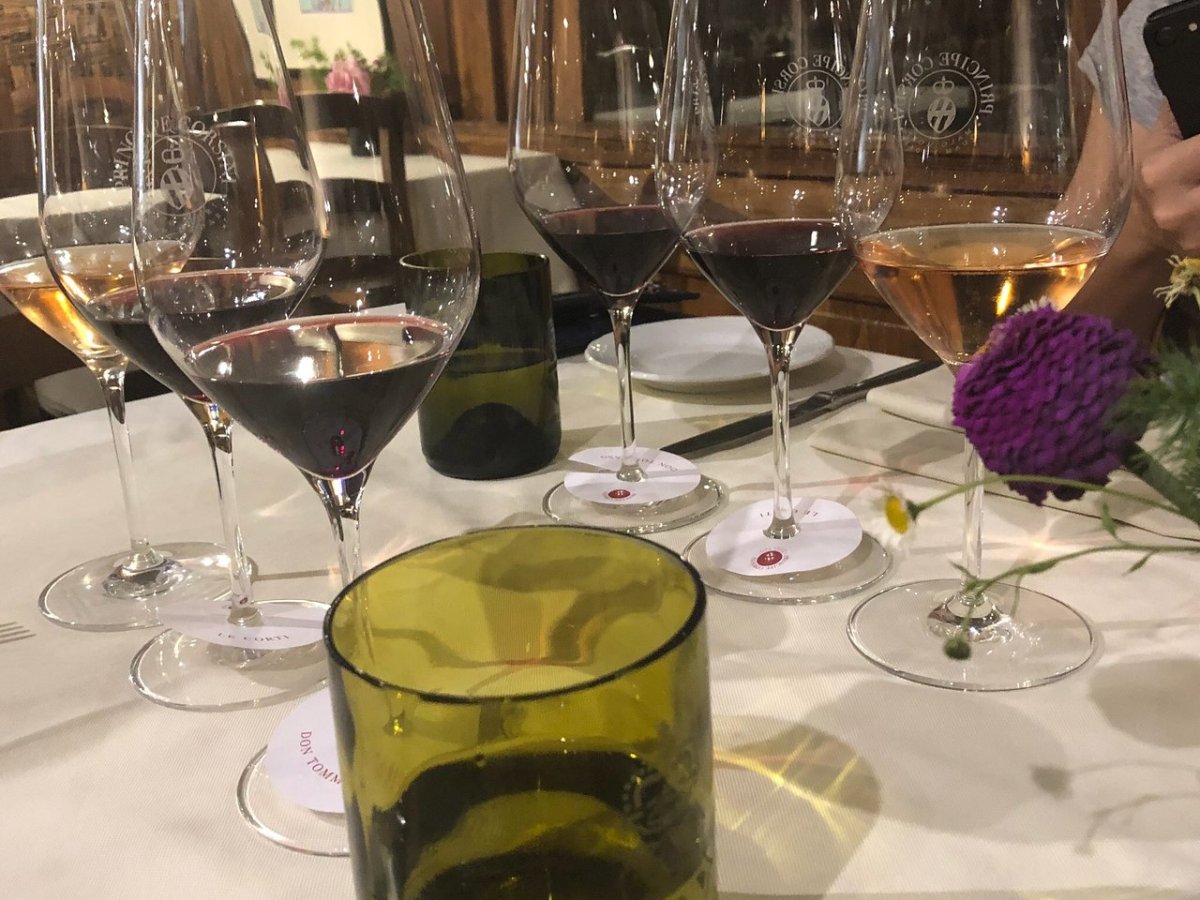 a glass of beer on a table with wine glasses