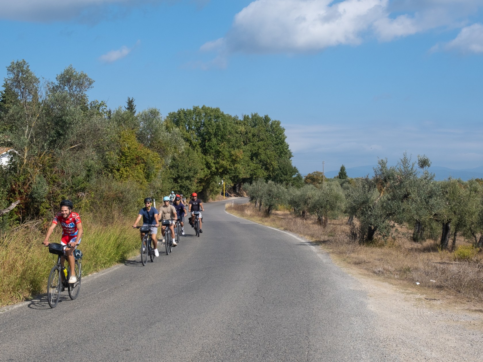 a group of people riding a motorcycle down a dirt road