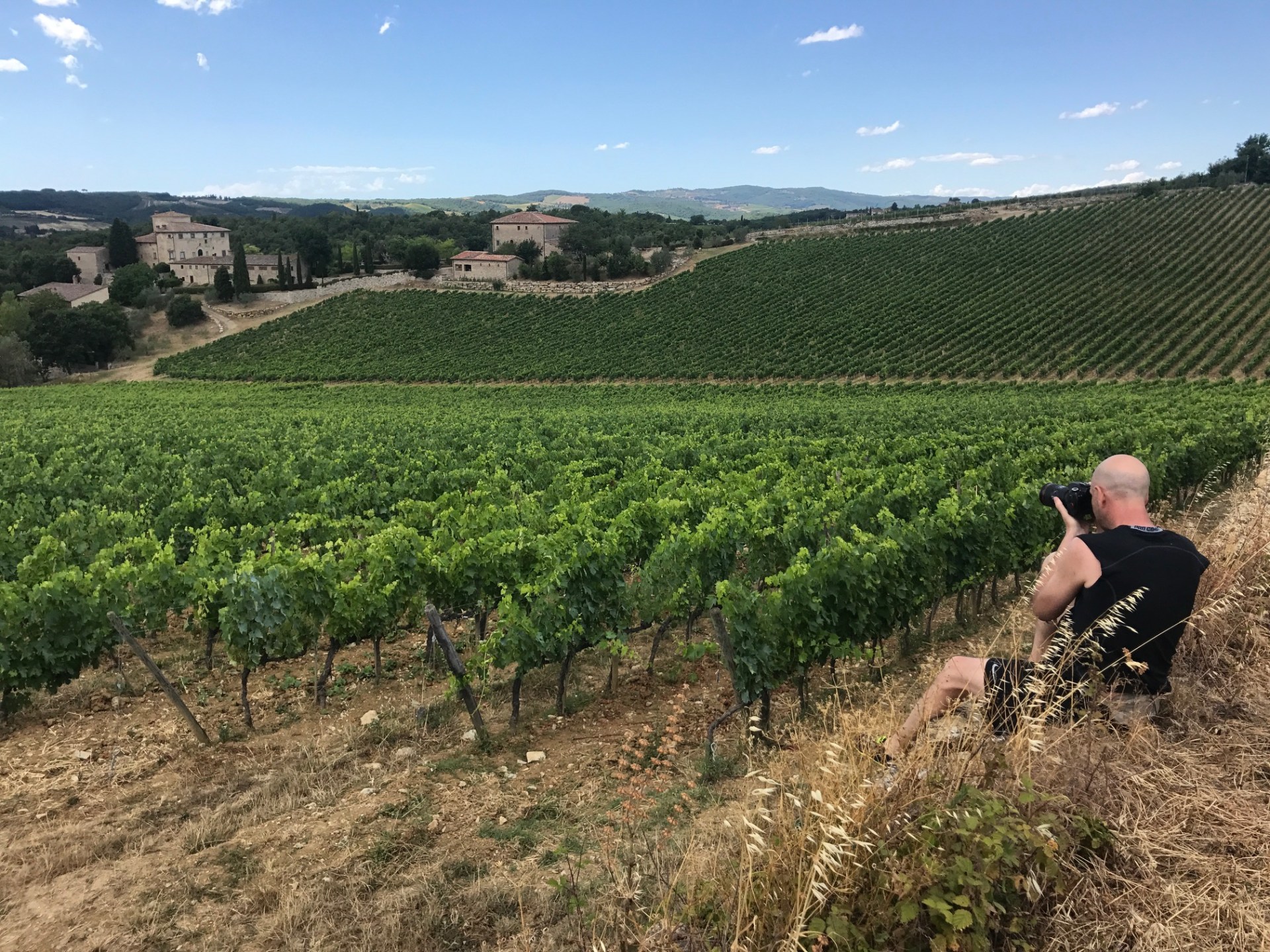 A man taking a picture in a vineyard Francigena trail