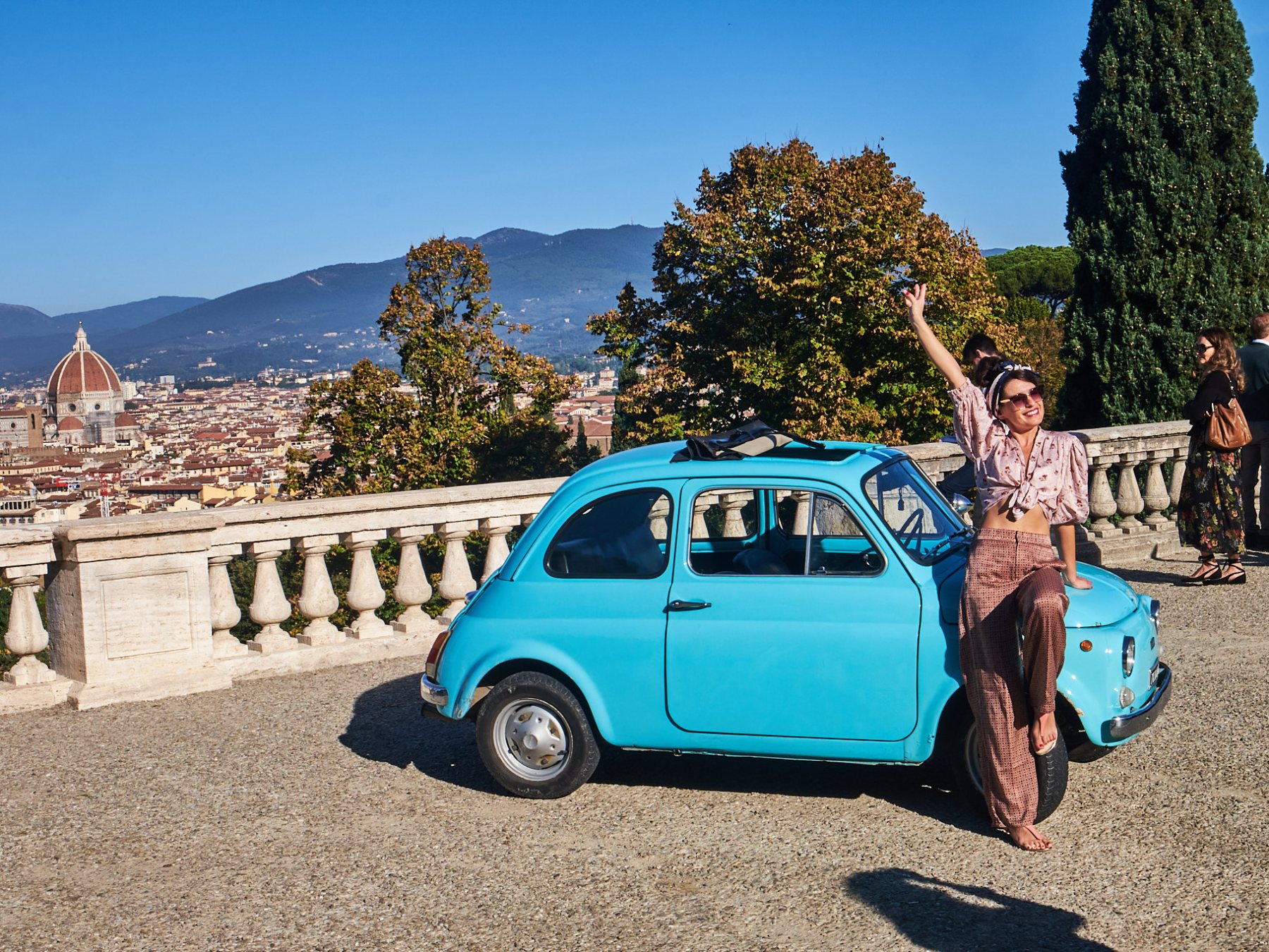 a group of people standing in front of a car