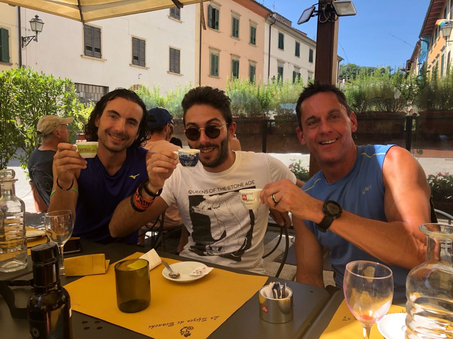 three men drinking coffee outside seating in restaurant