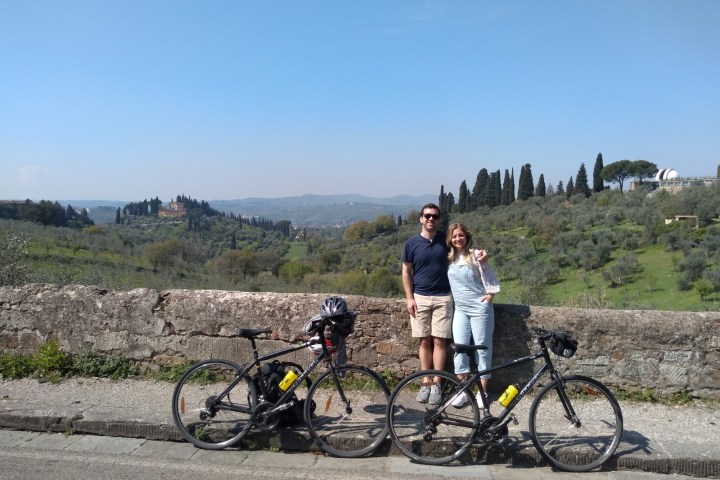 two people standing next to a bicycle