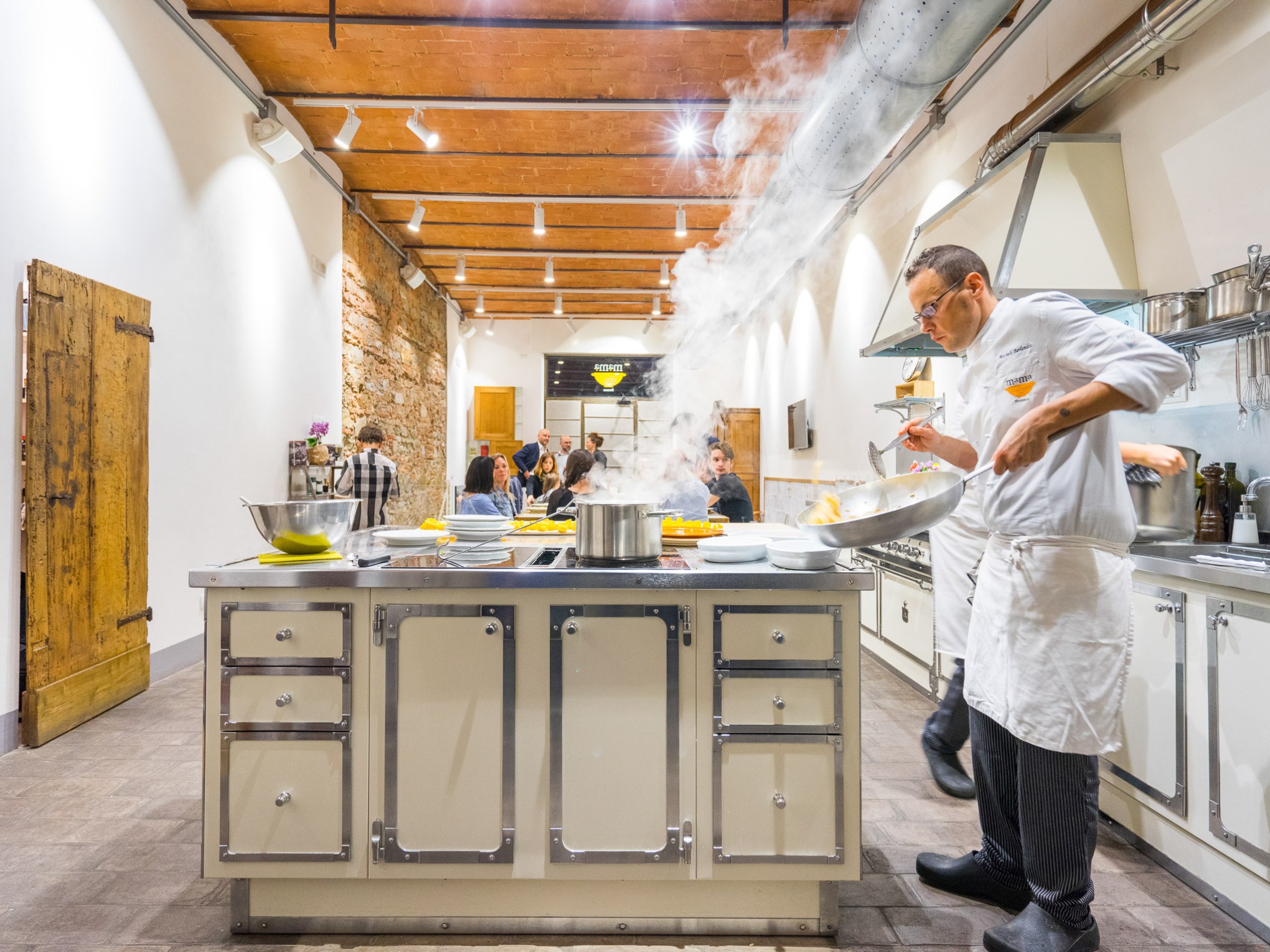 a couple of people that are standing in the kitchen