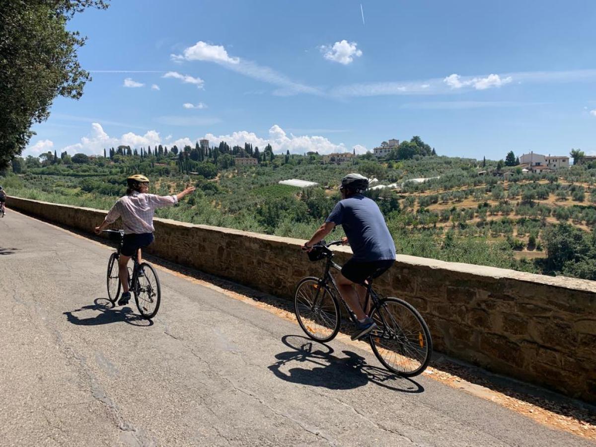 people riding a bicycle on the side of a road