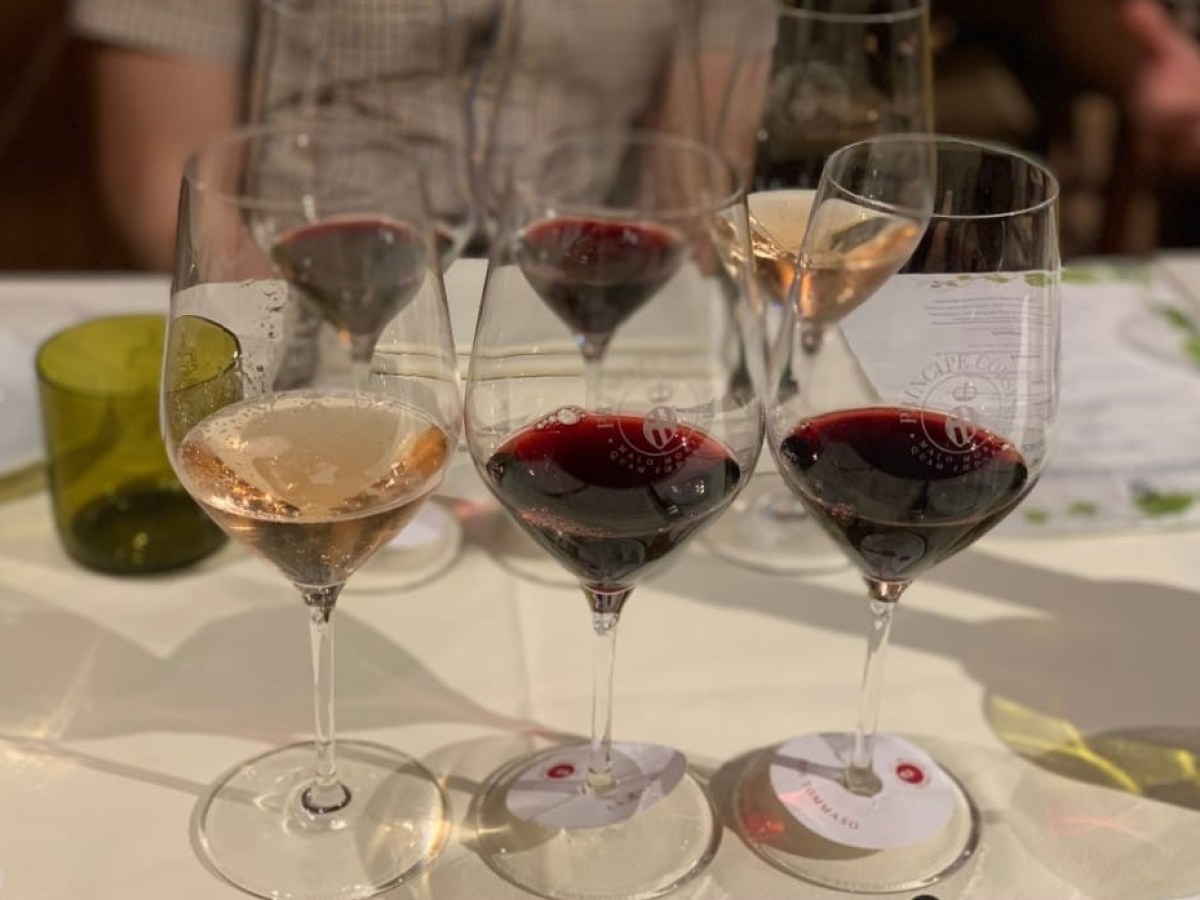 a group of empty glasses on a table next to a glass of wine
