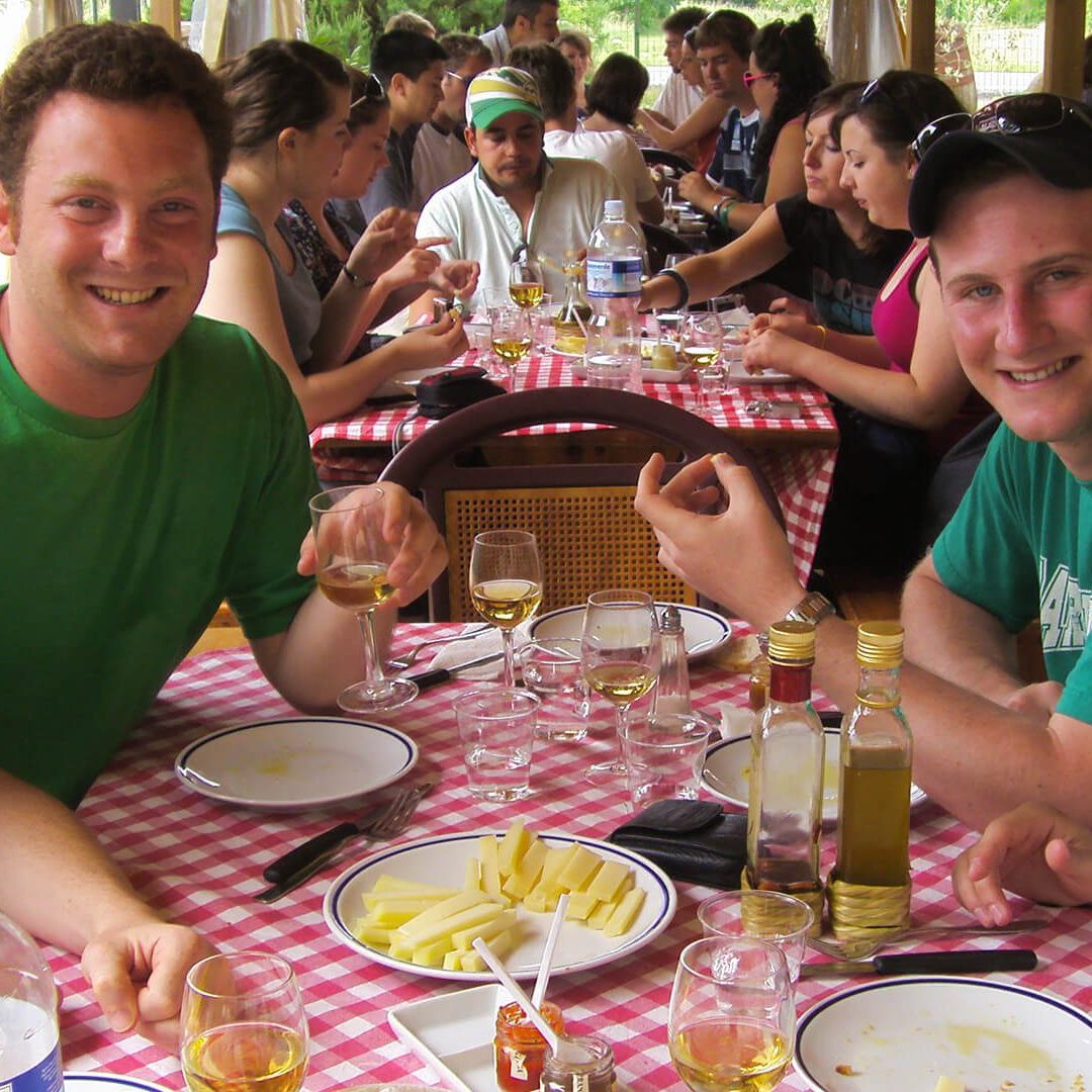 a group of people sitting at a table with a plate of food