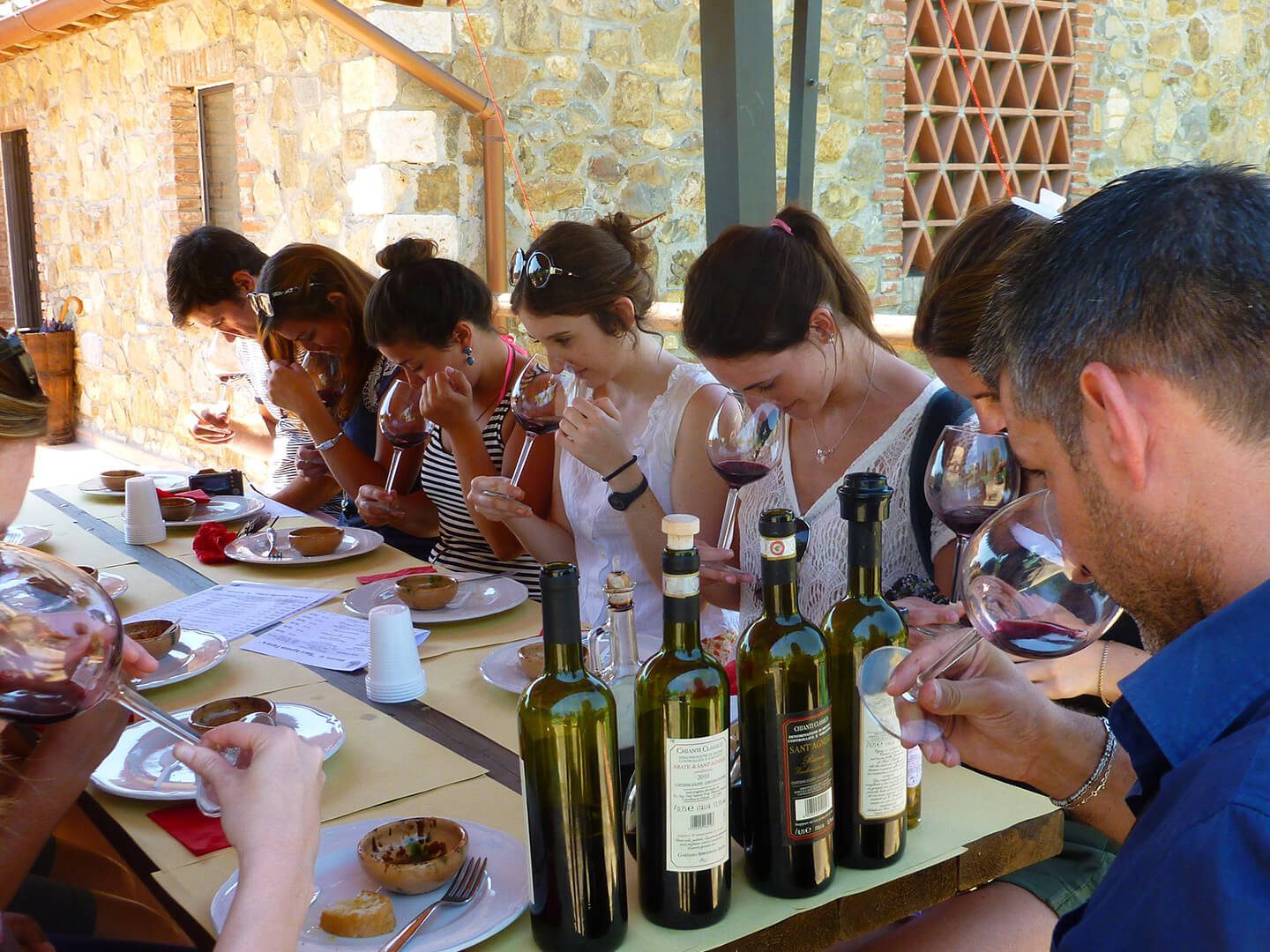 a group of people sitting at a table drinking wine