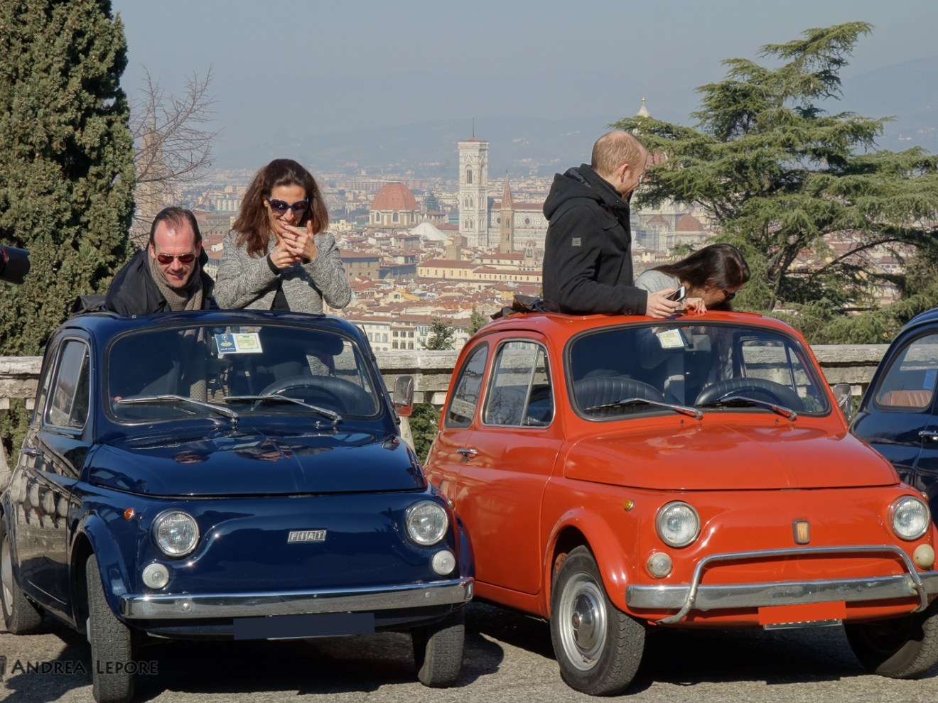 a group of people standing in front of a car posing for the camera