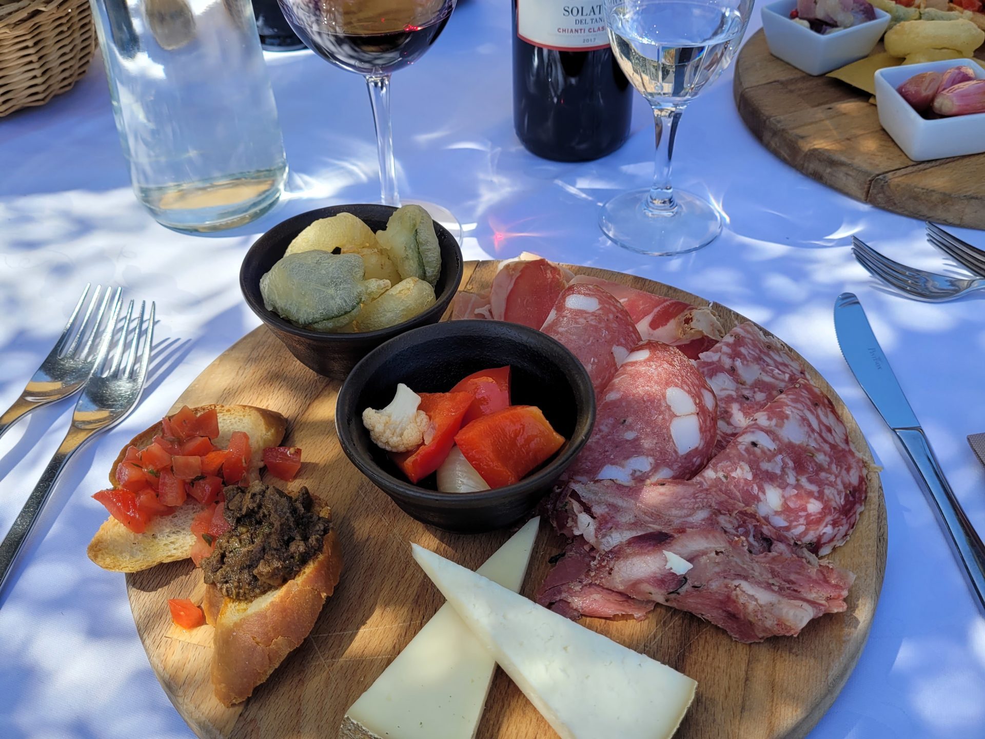 a plate of food and glasses of wine on a table
