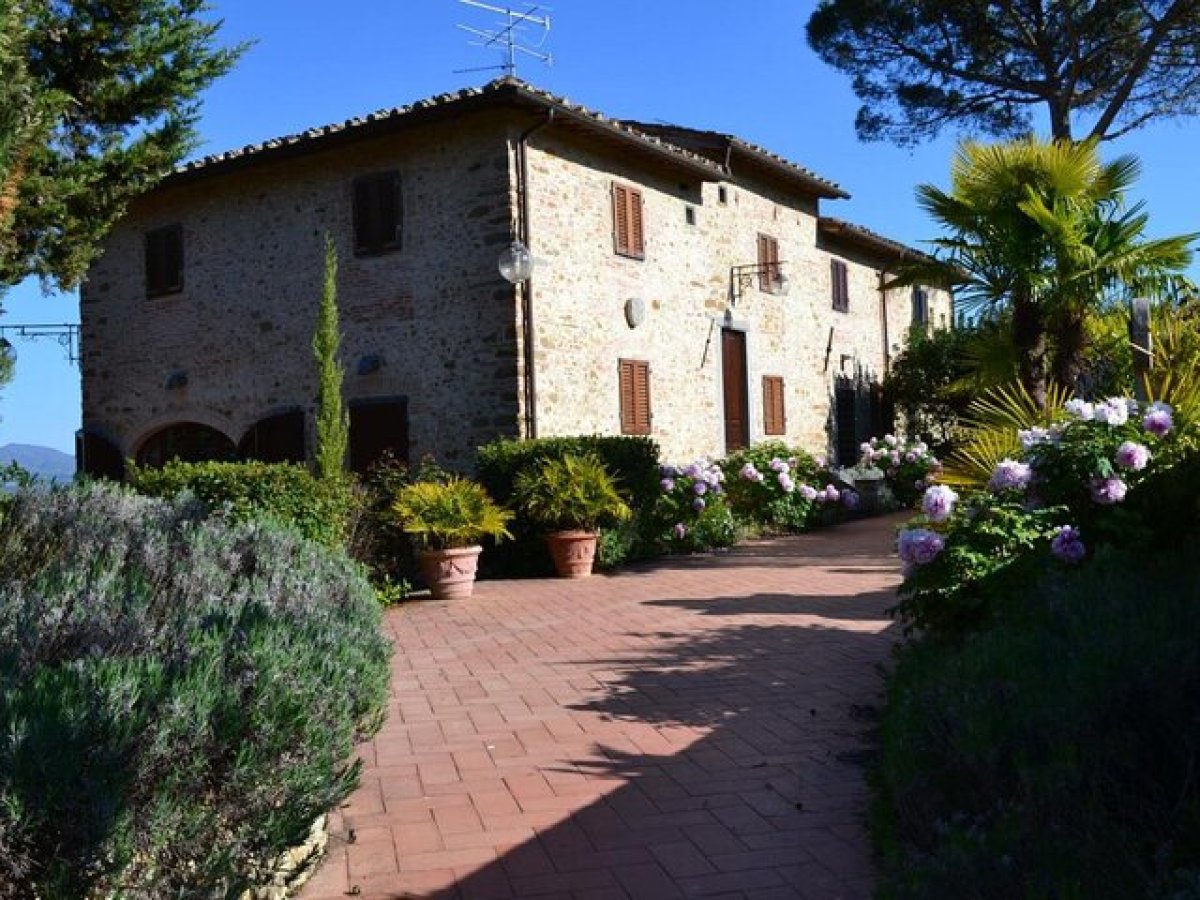 a house with bushes in front of a brick building