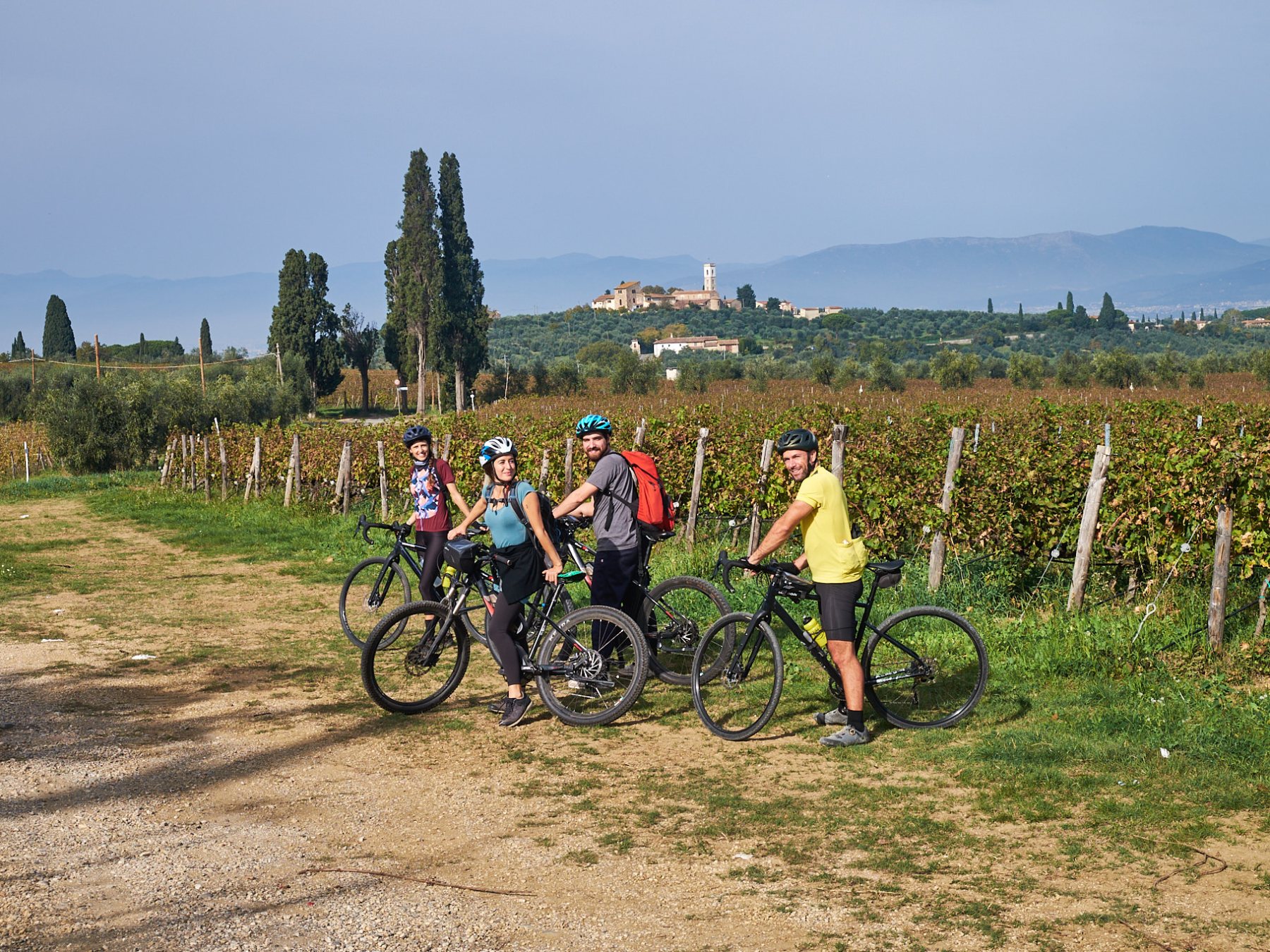 a group of people riding a motorcycle down a dirt road