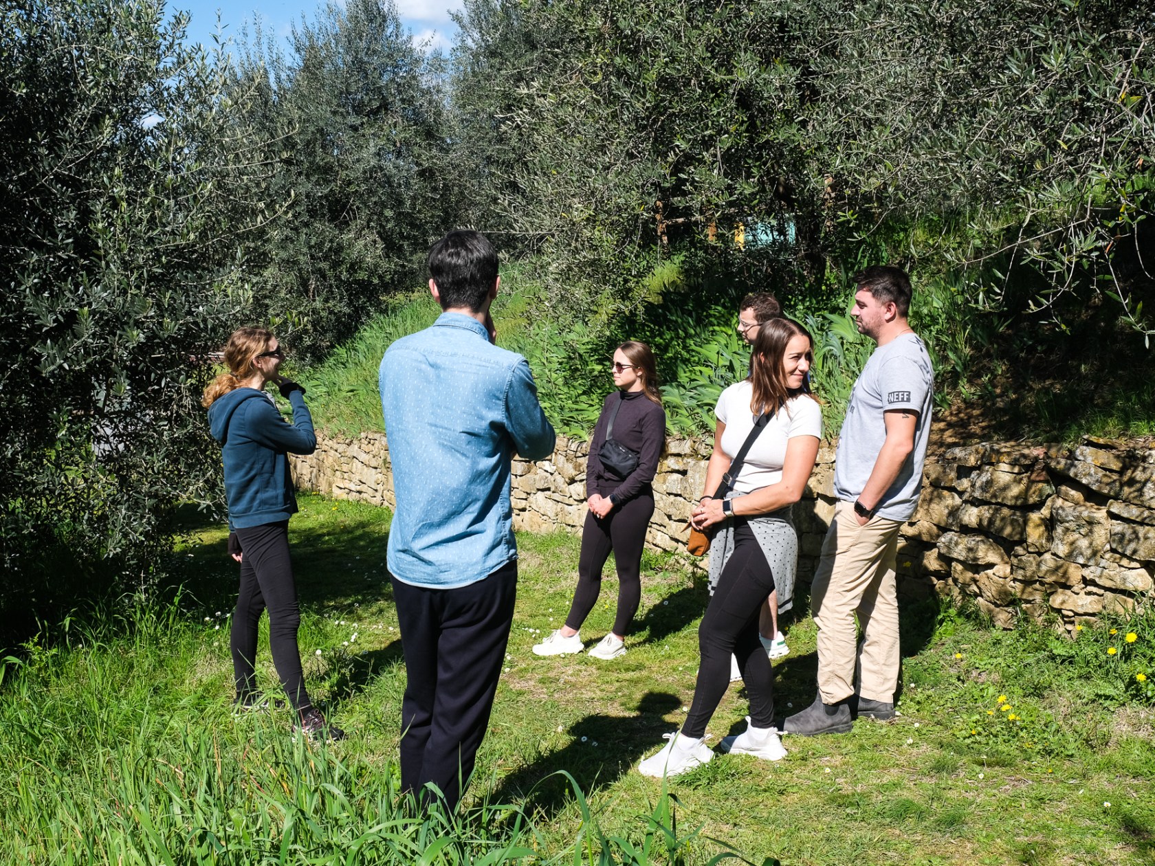 a group of people standing in front of a tree