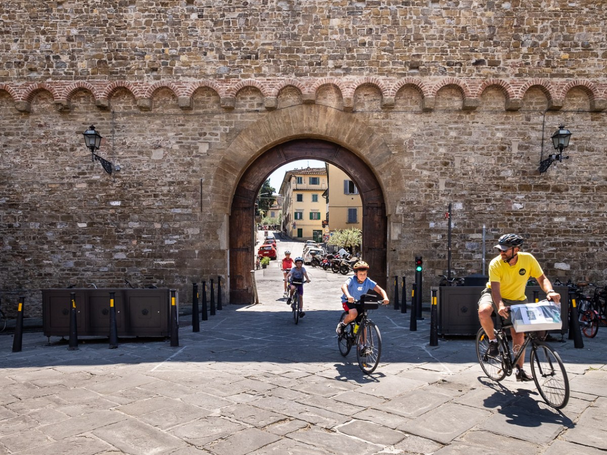 a group of people riding bikes on a stone building