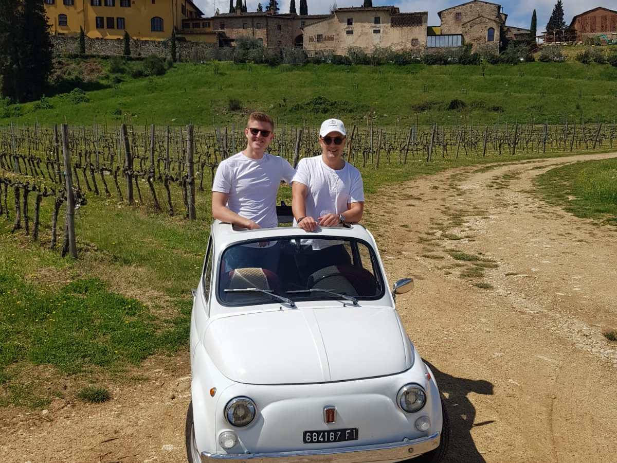 a man driving a car on a dirt road