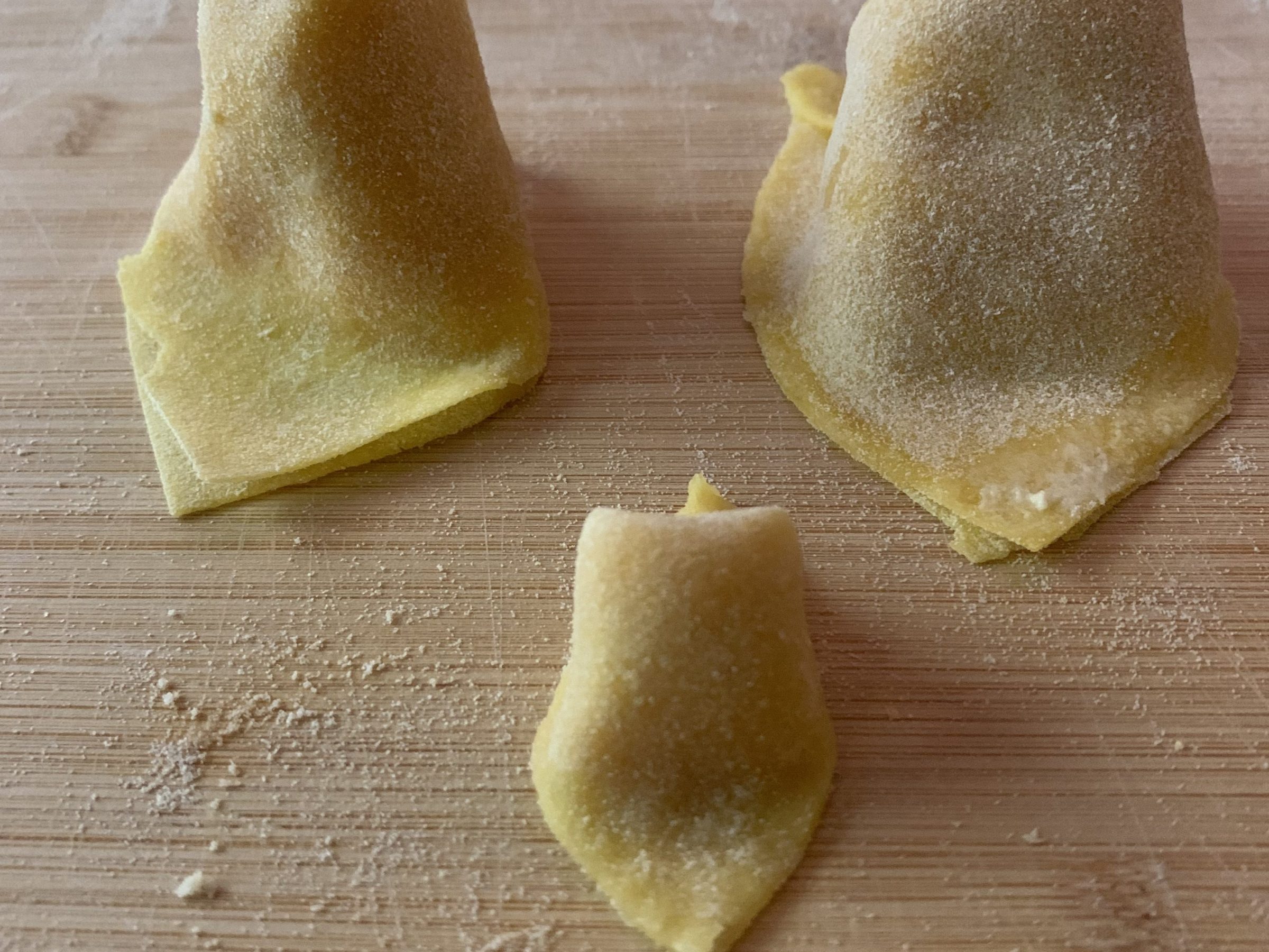 a piece of bread on a cutting board topped with a cut in half